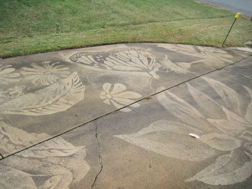 dianna wood uses power washer to create art on her dirty driveway